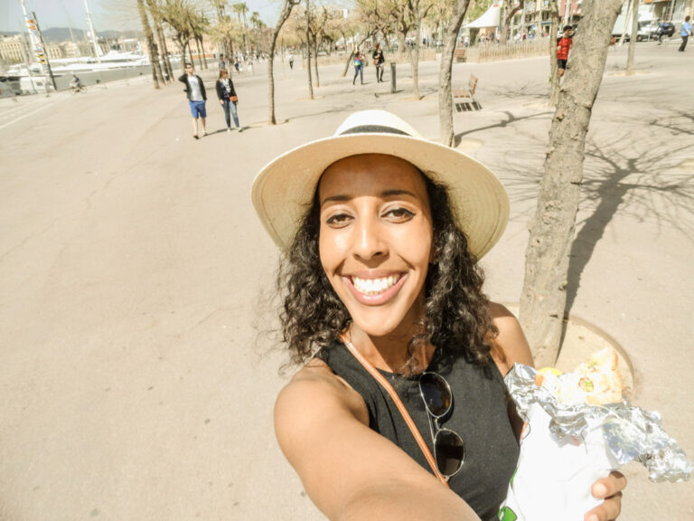Girl in Barcelona eating Bo d B sandwich near beach