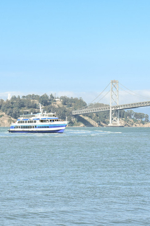 Boat with Treasure Island and Bay Bridge behind it
