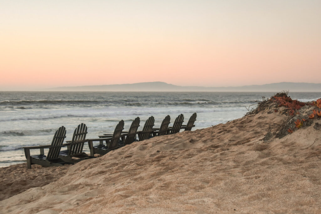 California beach sunset behind beach chairs