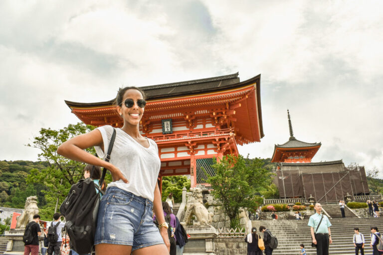 Girl in front of red temple in Kyoto Japan