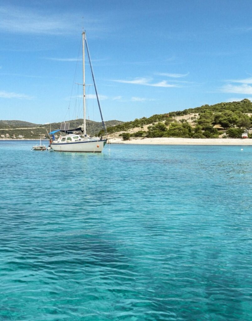 Small sail boat floating in blue water